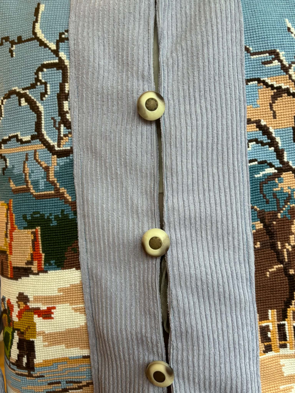 Close-up of button-and-loop fastening and ribbed blue fabric