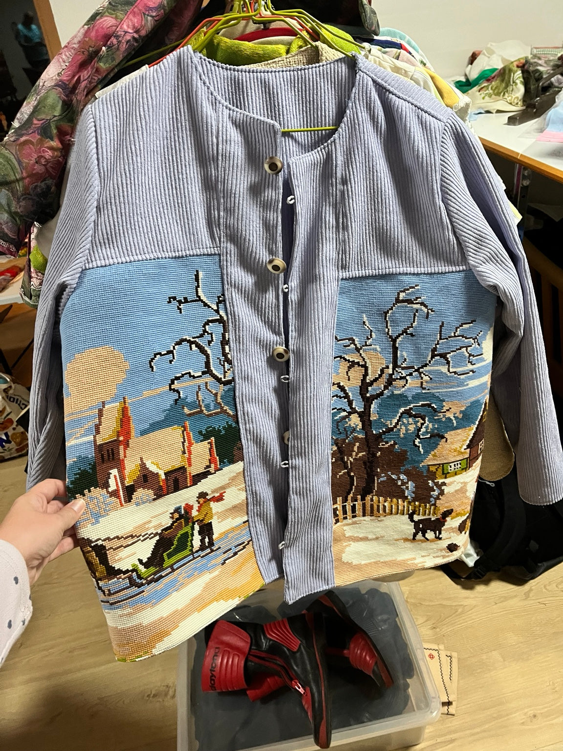 Front of winter-scene tapestry jacket on hanger